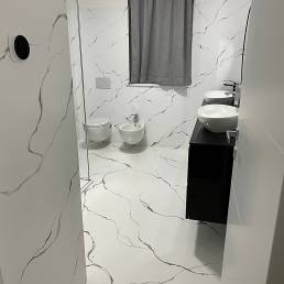 Moderno bagno con rivestimento effetto marmo.