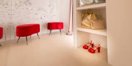 Interno negozio con sedute rosse ed accessori moda