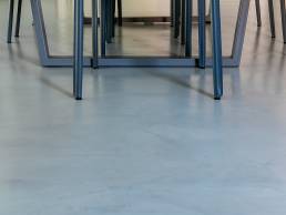 Gambe di sedie blu sotto tavolo