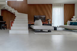 Soggiorno moderno con scala bianca sospesa