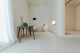 Bagno minimalista con tavolo in legno e bidet