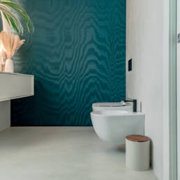 Bagno moderno con parete verde e sanitari sospesi
