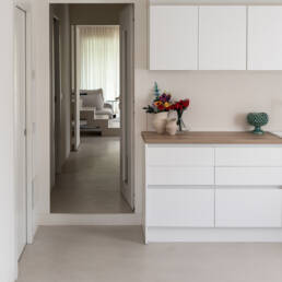 Ingresso moderno minimalista con mobili bianchi e fiori