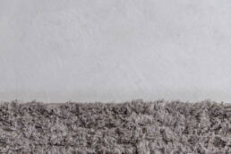 Parete chiara con tappeto grigio soffice