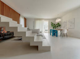 Soggiorno moderno con scala scultorea e zona pranzo