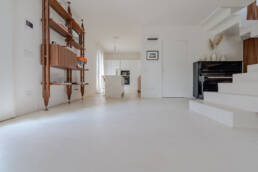 Interno minimalista con cucina bianca e pianoforte