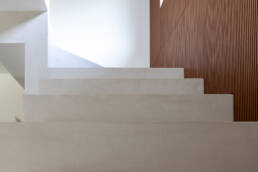 Scala minimalista in pietra con parete in legno