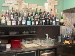 Bottiglie di liquori su mensola dietro bancone bar