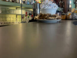 Bancone bar con bustine di zucchero e bottiglie