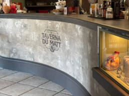 Bancone curvo della Taverna du Matt con bottiglie