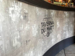 Bancone curvo della Taverna du Matt con bottiglie